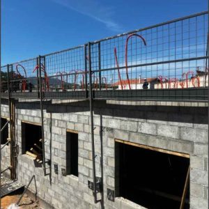 Proteção periférica metálica instalada em laje para segurança de trabalhadores na obra.